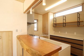 キッチンカウンターにもサクラの一枚板を採用し風情のある空間に