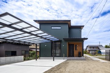 外壁：ガルバリウム鋼板（ヨドHyper GLカラー 萌 KS17H 緑）　アクセント：杉 羽目板　玄関ドア：LIXIL ジエスタ2 S12型 マットブラック