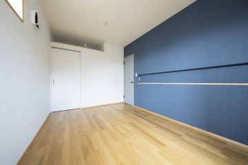 寝室：床材:ナラ複合フローリング クロス:ネイビーのアクセントクロスで、ゆったりとくつろげる寝室に。